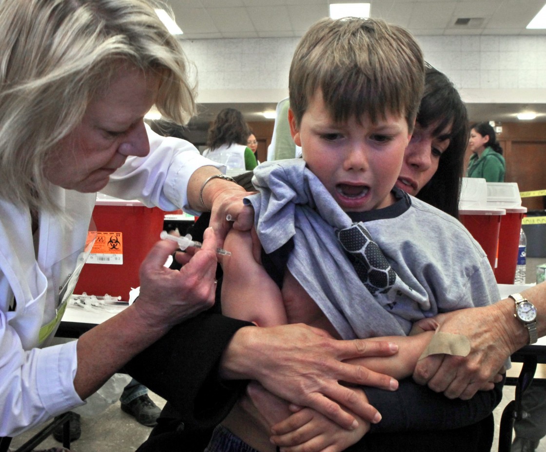 FILE - In this Nov. 16, 2009 file photo, Nathan Compton grimaces as he gets an H1N1 vaccination from nurse Leslie Trotter, left, as his mother Madeline Rubenstein, right, comforts him at a H1N1-swine flu clinic in Sacramento, Calif.