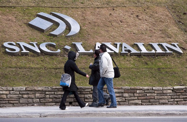 Pedestrians walk past the offices of SNC Lavalin, in Montreal, March 26, 2012.