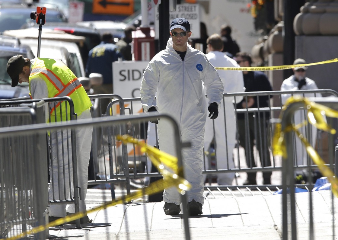 People in protective suits examine an area of Boylston Street in Boston Thursday, April 18, 2013, as investigation of the Boston Marathon bombings continues.