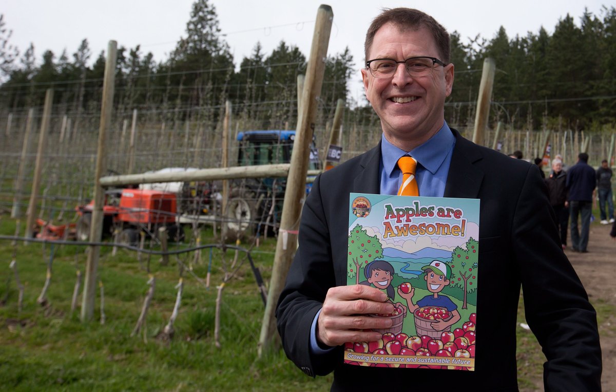 British Columbia NDP Leader Adrian Dix shows an apple book he was given during an election campaign stop at Sidhu Orchards in Lake Country, B.C., on Sunday April 21, 2013. British Columbians go to the polls for a provincial election May 14. THE CANADIAN PRESS/Darryl Dyck.