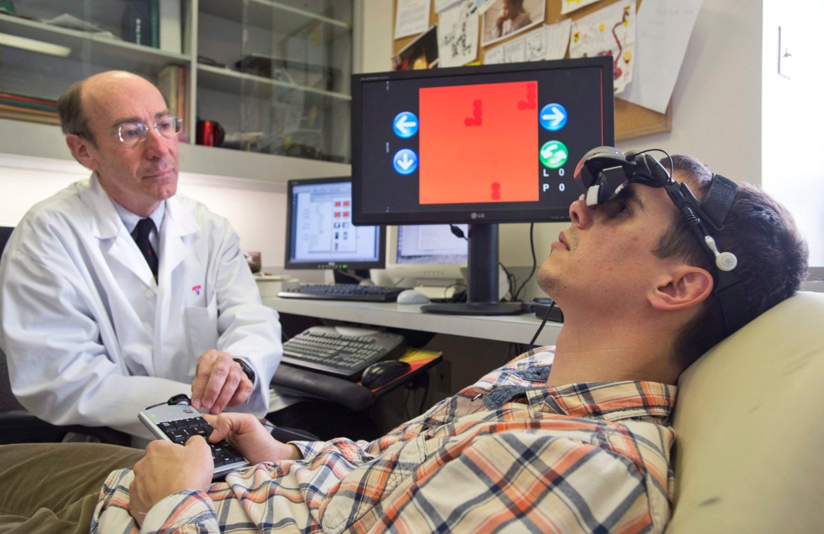 Professor Robert Hess, left, director of research at the department of ophthalmology at McGill University and Dr. Simon Clavagnier, a McGill vision research associate, demonstrate the effect of wearing goggles while playing the game Tetris has on a lazy eye in Montreal, Monday, April 22, 2013.