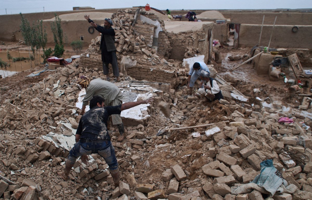 Afghan men look in the rubble of their destroyed homes for their belongings after a flood in Sholgara district, outside Mazar-e-Sharif, Afghanistan,.