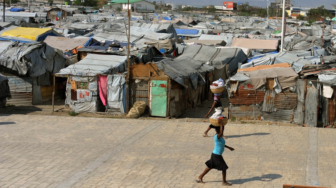 Women walk by a camp of survivors of the January 2010 quake in Haiti which killed 250,000 people, on February 28, 2013 in Port-au-Prince.