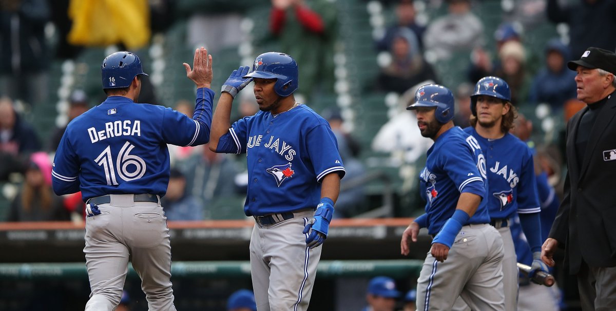 Edwin Encarnacion #10 of the Toronto Blue Jays celebrates with teammate Mark DeRosa #16 after scoring on the double to deep center field by J.P. Arencibia #9 in the seventh inning of the game against the Detroit Tigers at Comerica Park on April 10, 2013 in Detroit, Michigan.