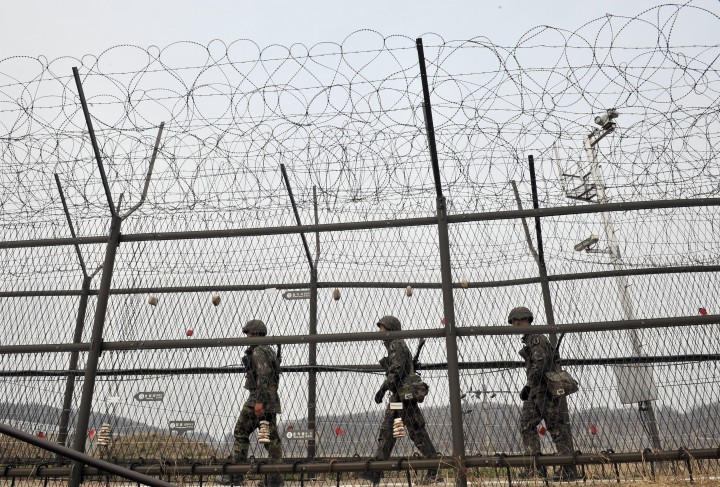 South Korean soldiers patrol along a military fence near the Demilitarized Zone (DMZ) dividing the two Koreas in the border city of Paju on April 16, 2013.