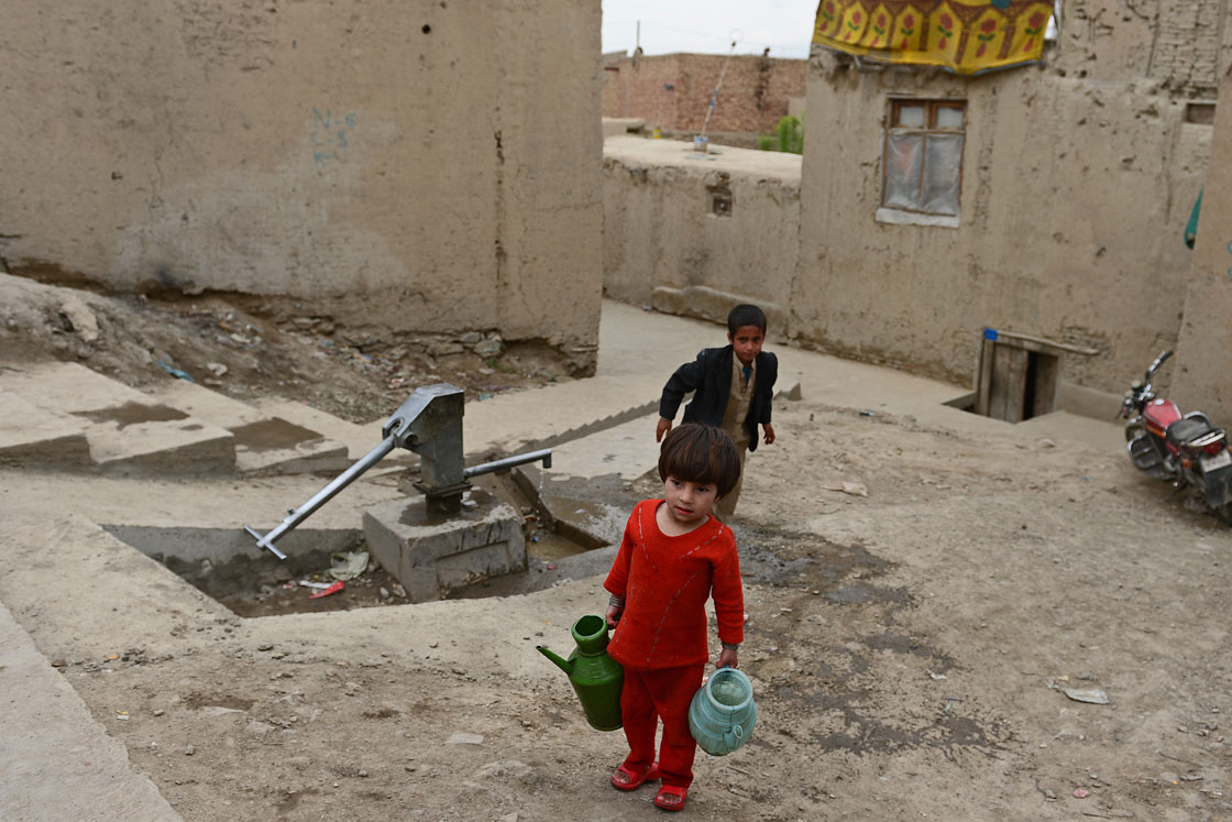 An Afghan child carries water from a well in Kabul on April 22, 2013. 