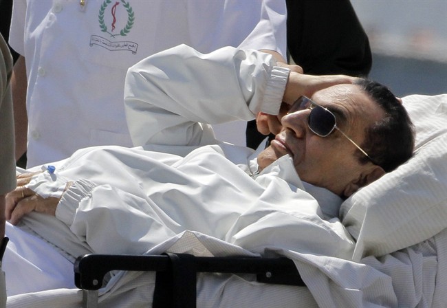 Egyptian medics and army personnel escort former Egyptian President Hosni Mubarak from a helicopter ambulance after it landed at Maadi Military Hospital following a hearing in his retrial in Cairo, Egypt, Saturday, April 13, 2013. Egypt's highest court in January ordered a retrial for Mubarak, for failing to stop the killing of 900 protestors in the 2011 unrest that ousted him, after accepting an appeal against his life sentence, citing procedural failings. 