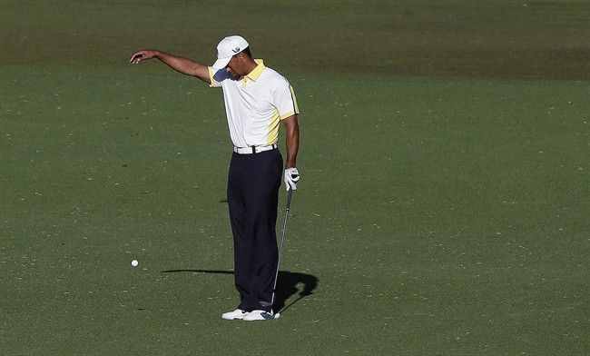 Tiger Woods takes a drop on the 15th hole after his ball went into the water during the second round of the Masters golf tournament Friday, April 12, 2013, in Augusta, Ga. The drop is being reviewed by the rules committee.
