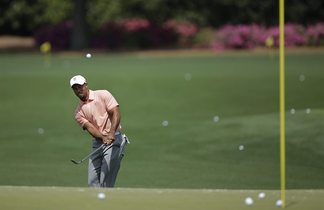 Tiger Woods chips to a putting green on the driving range during a practice round for the Masters golf tournament Tuesday, April 9, 2013, in Augusta, Ga.