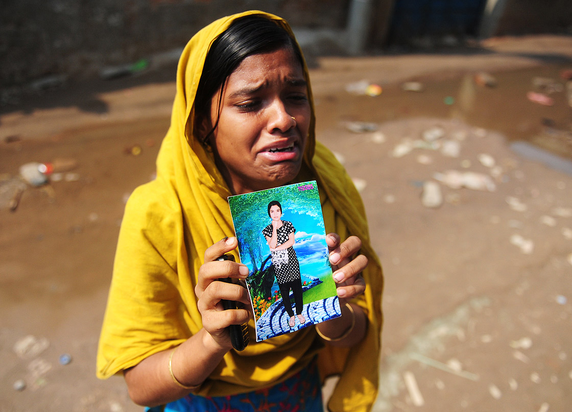 A Bangladeshi woman shows a portrait of her missing twin sister, believed trapped in the rubble 48 hours after an eight-storey building collapsed in Savar, on the outskirts of Dhaka, on April 26, 2013. 