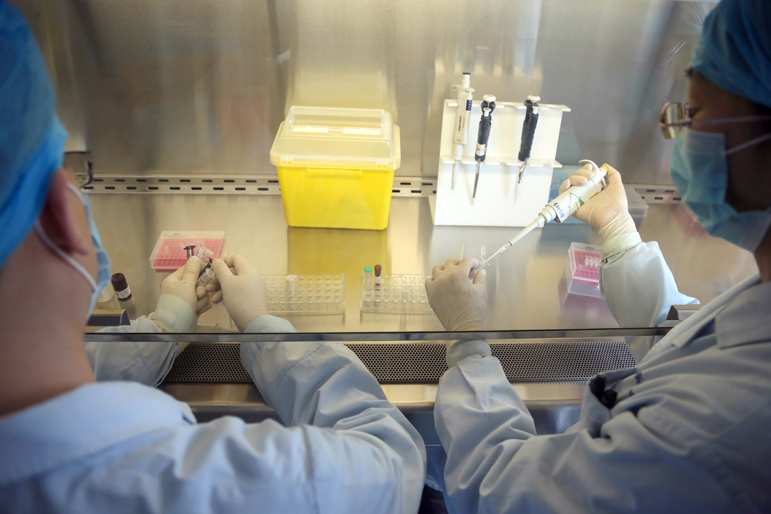 This picture taken on April 3, 2013 shows Chinese health workers preparing an H7N9 virus detection kit at the Center for Disease Control (CDC) in Beijing.