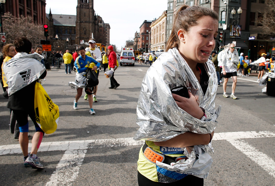 An unidentified Boston Marathon runner leaves the course crying near Copley Square following an explosion in Boston Monday, April 15, 2013.