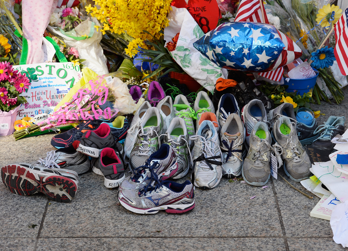Running shoes are placed at a makeshift memorial for victims near the finish line of the Boston Marathon bombings at the intersection of Boylston Street and Berkley Street on April 21, 2013 in Boston, Massachusetts.