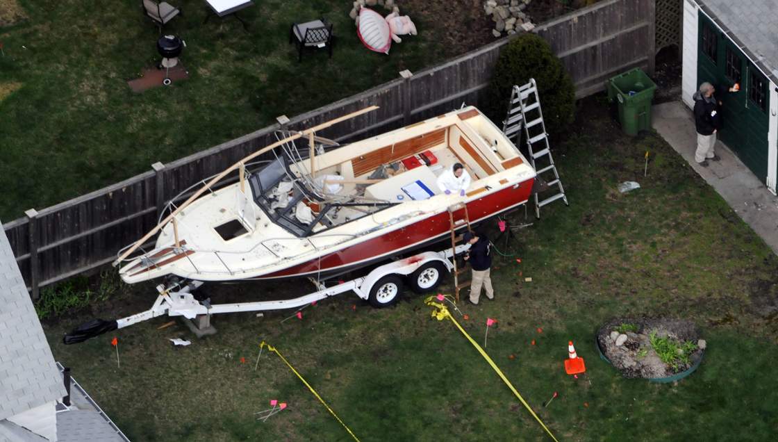 Investigators work around the boat where Dzhokhar A. Tsarnaev was found hiding after a massive manhunt, in the backyard of a Franklin Street home, in an aerial view April 20, 2013 in Watertown, Massachusetts.