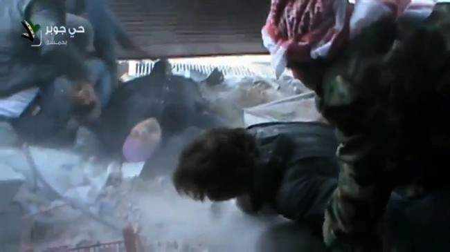 This image taken from video obtained from Shaam News Network, which has been authenticated based on its contents and other AP reporting, shows an injured Syrian woman rescued by rebels from a firefight in a street in the Jobar neighborhood in Damascus, Syria, Wednesday, April 10, 2013. Syrian President Bashar Assad's troops battled rebels in the outskirts of Damascus on Wednesday and pressed on with a counteroffensive against opposition fighters in the south to prevent their advance on the capital.(AP Photo/Shaam News Network via AP video).