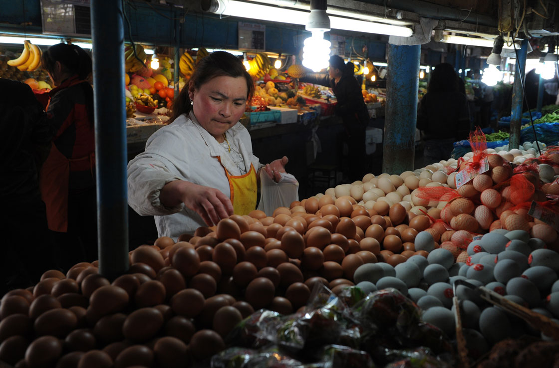 A woman buys eggs in a market in Shanghai on April 9, 2013.  China's deadly bird flu outbreak has dealt a "devastating" blow to the nation's poultry sector, an industry group said, with sales reportedly plunging amid concerns over food safety.    