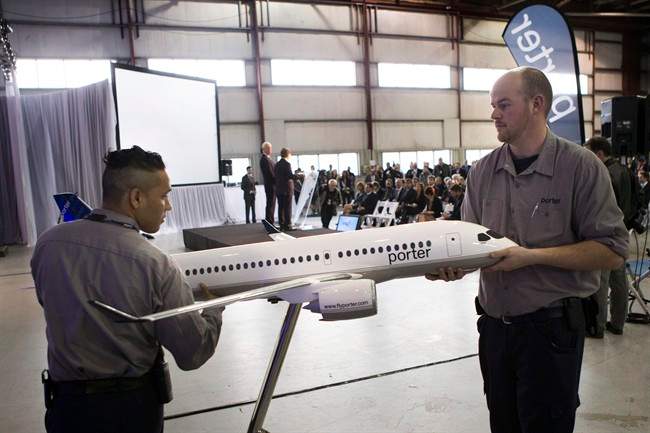 Employees position a model CS100 Aircraft as Bob Deluce, President and CEO of Porter Airlines and the company's Chairman Don Carty take question from the media after he announces the Airlines purchase of 12 of the planes, with an option for a further 18, at a news conference in Toronto on Wednesday April 10, 2013.