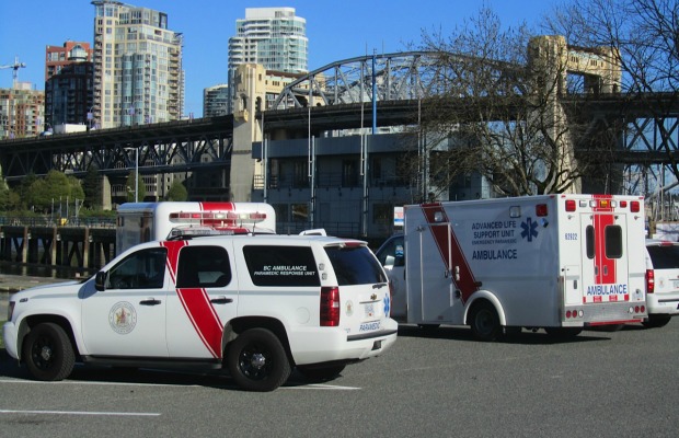 Paramedics wait at closed Kitsilano Coast Guard base to be picked up by Vancouver police boat to attend crew member aboard freighter who had suffered a heart attack.