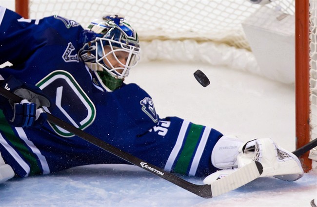 Vancouver Canucks' goalie Cory Schneider stops Detroit Red Wings' Justin Abdelkader during the third period of an NHL hockey game in Vancouver, B.C., on Saturday April 20, 2013. 