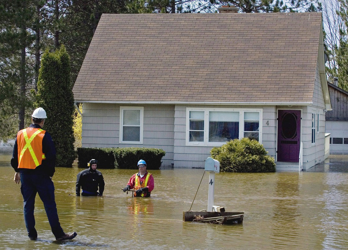 Wokers turn off the water supply to a flooded house in Fredericton on Thursday, May 1, 2008. 