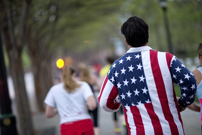 Conn Jackson, of Atlanta, right, wears a shirt decorated with the flag of the United States as he takes part in an organized moment of silence and memorial run to show solidarity with victims of the Boston Marathon bombing, Tuesday, April 16, 2013, in Atlanta. (AP Photo/David Goldman).