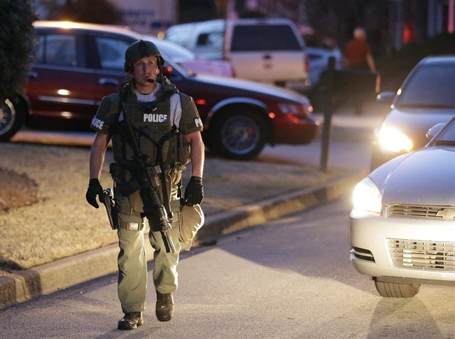 A police officer leaves the scene after an explosion and gunshots were heard near the scene where a man was holding four firefighters hostage Wednesday, April 10, 2013 in Suwanee, Ga. 