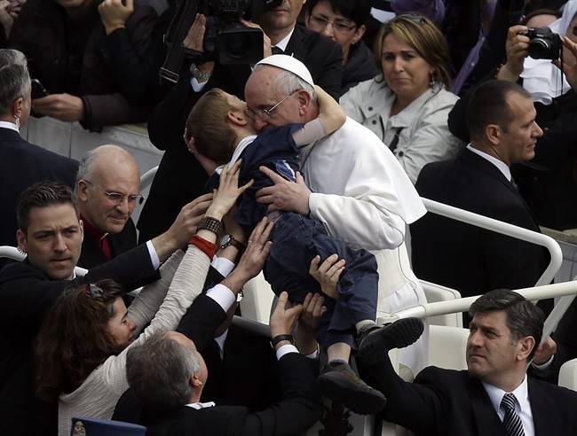 Pope Francis hugs a child after celebrating his first Easter Mass in St. Peter's Square at the Vatican, Sunday, March 31, 2013. Pope Francis celebrated his first Easter Sunday Mass as pontiff in St. Peter's Square, packed by joyous pilgrims, tourists and Romans and bedecked by spring flowers.Wearing cream-colored vestments, Francis strode onto the esplanade in front of St. Peter's Basilica and took his place at an altar set up under a white canopy.