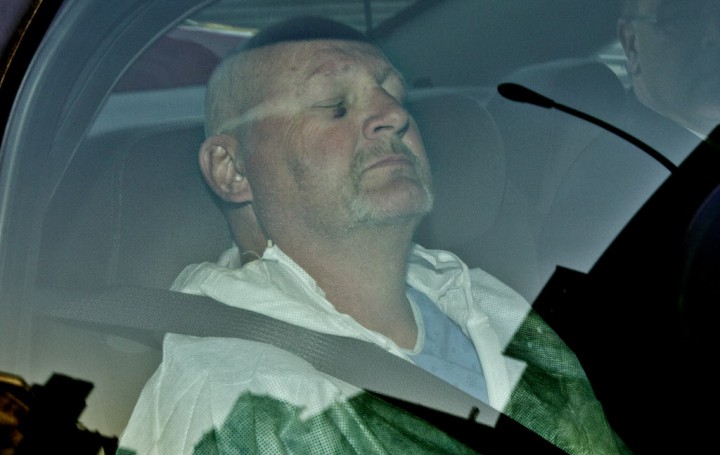 Shooting suspect Richard Henry Bain sits with his eyes closed in the back of a police car, as he arrives at the Montreal courthouse, April 4, 2013.