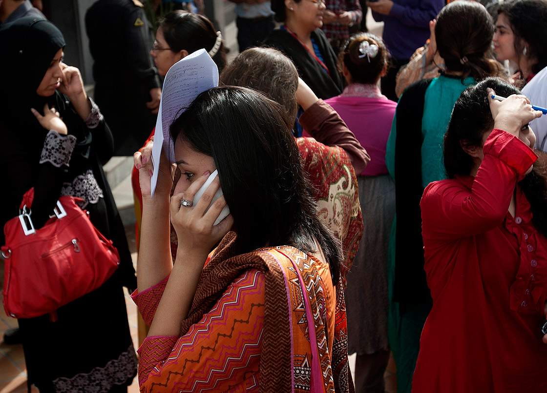 People evacuate buildings after a major earthquake hit Karachi, Pakistan, Tuesday, April 16, 2013.