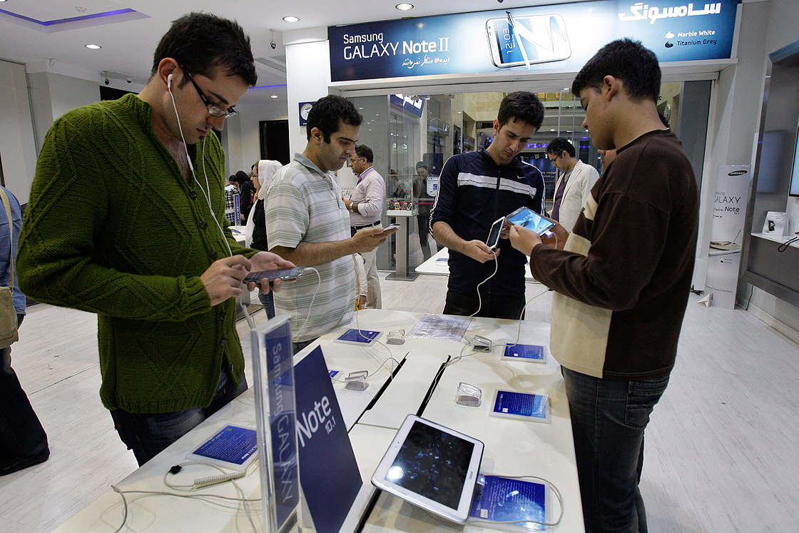 Potential customers try out Samsung cell phones in a store in Tehran, Iran, Thursday, Nov. 8, 2012. 