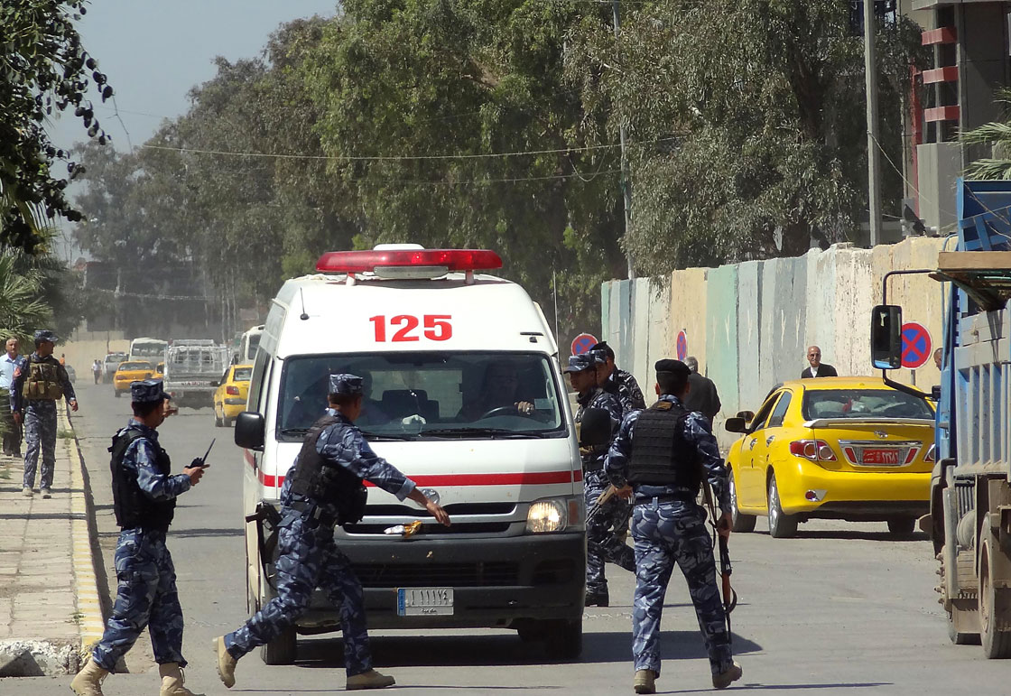 Iraqi soldiers surround an ambulance as it arrives at a hospital following clashes on April 23, 2013 in the northern city of Kirkuk.  
