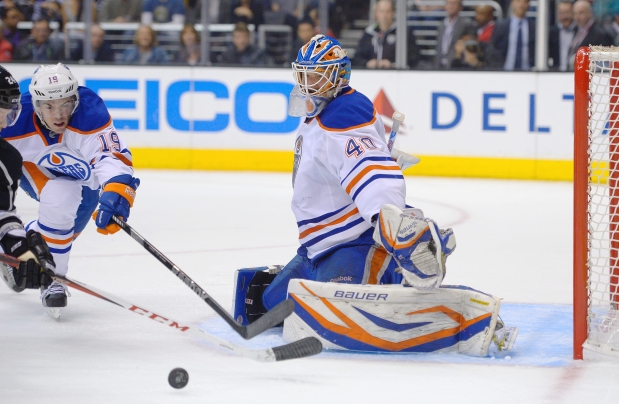 Edmonton Oilers defenceman Justin Schultz tries to poke-check the puck away from Los Angeles Kings center Colin Fraser in front of goaltender Devan Dubnyk during Saturday’s NHL game at the Staples Center in L.A.