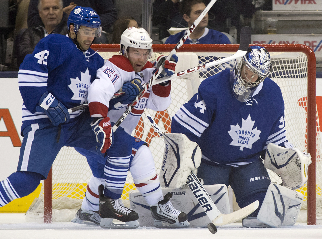 Toronto Maple Leafs goaltender James Reimer gets whacked in the head as centre Nazem Kadri (43) tries to hold off Montreal Canadiens centre David Desharnais (51) during second period NHL action in Toronto on Saturday April 27, 2013. 