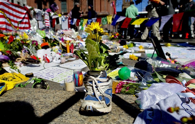 A memento of flowers in a running shoe rests at a makeshift memorial in Boston’s Back Bay neighborhood on Thursday, April 18, 2013, a few blocks from the finish line of the Boston Marathon, where people continue to bring special objects to mourn and honor those who were killed and injured after two bombs exploded at the finish line of the race.