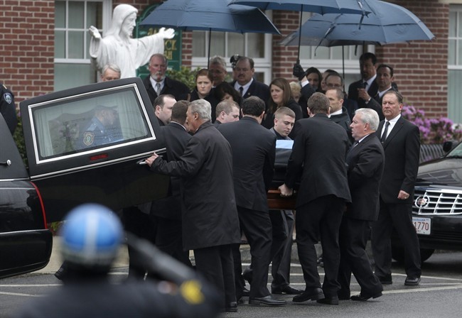 Pallbearers carry the casket of fallen Massachusetts Institute of Technology police officer Sean Collier into St. Patrick's Church before a funeral Mass, in Stoneham, Mass., Tuesday, April 23, 2013.