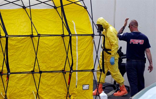 A Prince George's County, Md. firefighter dressed in a protective suit walks out of a government mail screening facility in Hyattsville, Md., Wednesday, April 17, 2013. Police swept across the U.S. Capitol complex to chase a flurry of reports of suspicious packages and envelopes Wednesday after preliminary tests indicated poisonous ricin in two letters sent to President Barack Obama and a Mississippi senator.