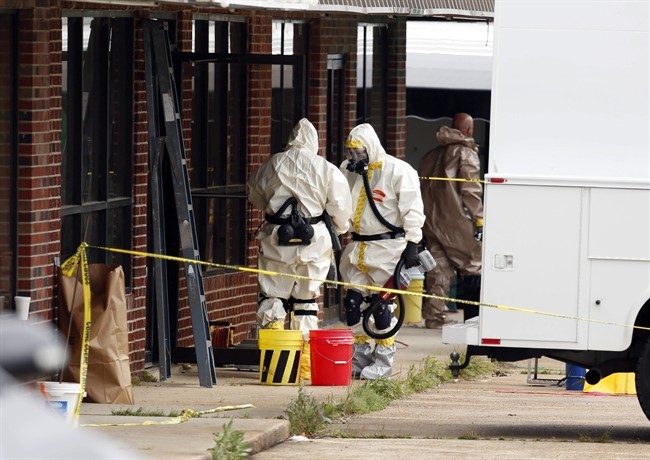 

Federal authorities, some in hazmat suits, walk outside the staging area as they search at a small retail space where neighboring business owners said Everett Dutschke used to operate a martial arts studio, in connection with the recent ricin attacks, Wednesday, April 24, 2013 in Tupelo, Miss.
