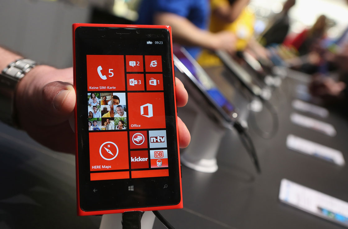 A stand host holds up a Nokia Lumia 920 Windows enabled smartphone at the Microsoft stand at the 2013 CeBIT technology trade fair.