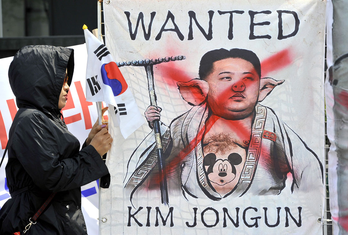 A South Korean activist holds a placard showing a caricature of North Korean leader Kim Jong-Un during an anti-North Korea rally in Seoul on April 18, 2013. 