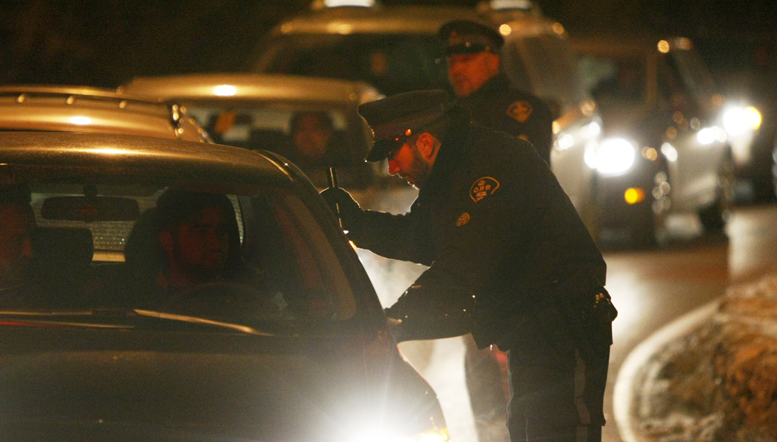 Constable Danny Rodrigues (L) and Constable Roch Durivage interview drivers during a ride program at the Maitland 417 west bound ramp in Ottawa, December 22, 2009. 