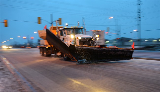 A snow plow salts Highway 7 in Carleton Place, Ont. on Friday, April 12, 2013, as a major winter storm hits. THE CANADIAN PRESS/Sean Kilpatrick.