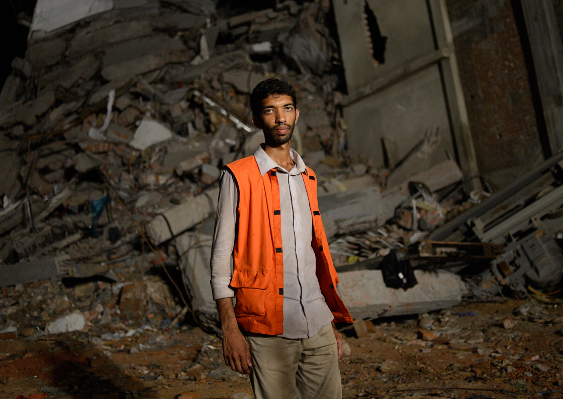 FILE - In this April 29, 2013 file photo, Volunteer Saiful Islam Nasar poses in front of the rubble of a building collapse in Savar, near Dhaka, Bangladesh. Nasar had no training and almost no equipment.