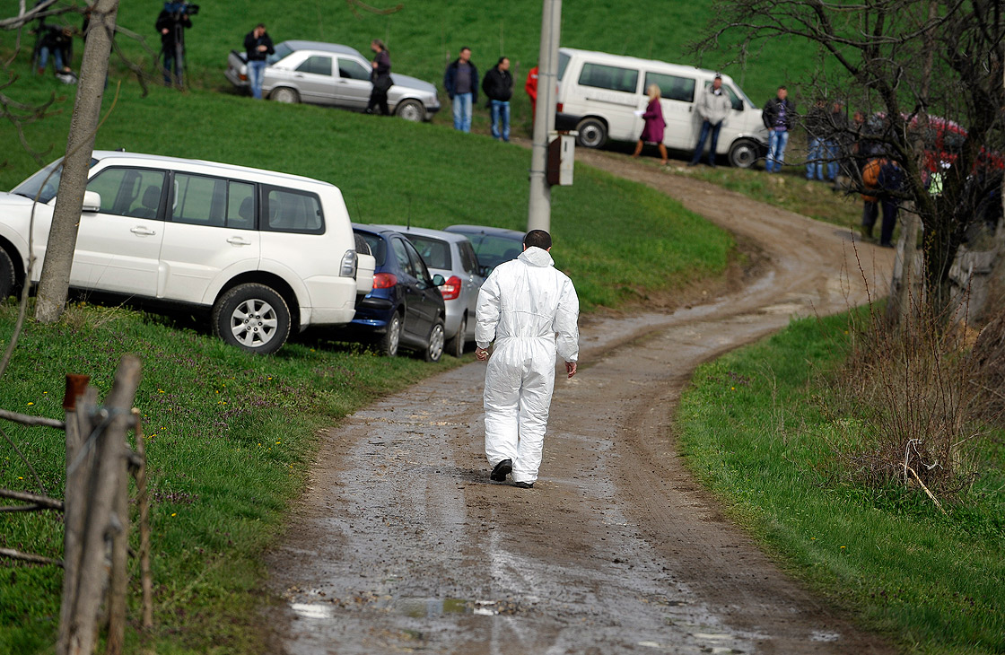 A Serbian forensic expert walks toward the site where a man shot dead 13 relatives and neighbours, including a two-year-old child, in the village of Velika Ivanca, 40 kilometres south of capital Belgrade, on April 9, 2013. 