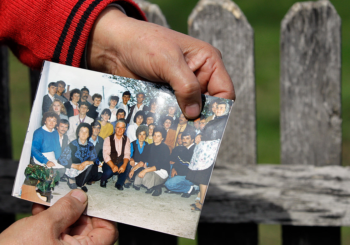 A woman displays Ljubisa Bogdanovic with her left thumb in a group picture in the village of Velika Ivanca, Serbia, Tuesday, April 9, 2013. The 60-year-old man gunned down 13 people, including a baby, in a house-to-house rampage in the quiet village on Tuesday before trying to kill himself and his wife, police and hospital officials said. Belgrade emergency hospital spokeswoman Nada Macura said the man, identified as Ljubisa Bogdanovic, used a handgun in the shooting spree at five houses. The dead included six women.