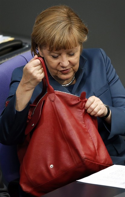 German Chancellor Angela Merkel looks into her handbag during a meeting of the German federal parliament, Bundestag, on the EU financial assistance for Cyprus in Berlin, Germany, Thursday, April 18, 2013.