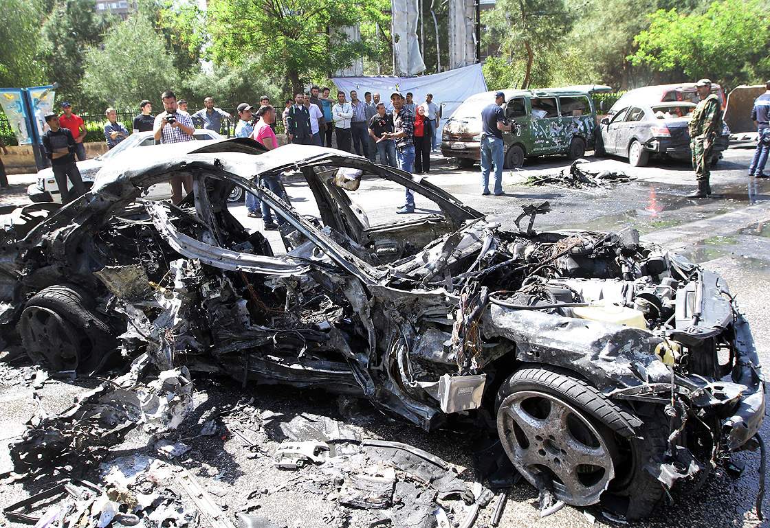 People gather at the scene of an explosion in the Mazzeh district of the Syrian capital Damascus on April 29, 2013, which is believed to have targeted the prime minister’s convoy.