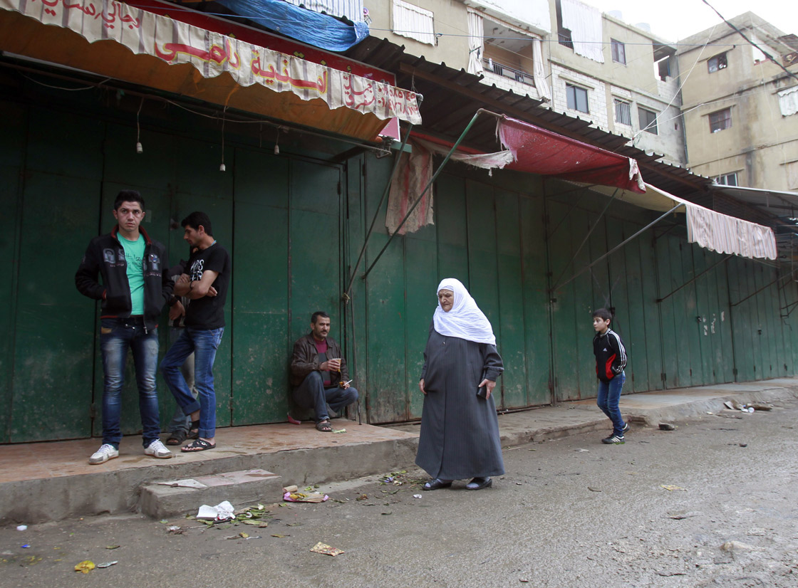 A Lebanese woman walks past closed shops owned by Syrian nationals at the Shiite dominant neighbourhood of Hay al-Selloum in a Beirut southern suburb on April 10, 2013.