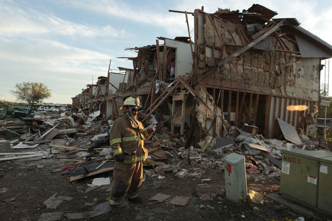 WEST, TX - APRIL 18: A Valley Mills Fire Department personnel walks among the remains of an apartment complex next to the fertilizer plant that exploded yesterday afternoon on April 18, 2013 in West, Texas.