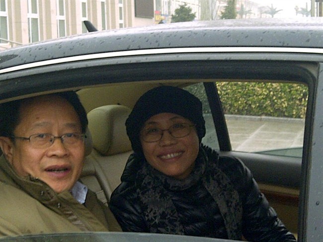 Liu Xia, wife of jailed Nobel Peace Prize winner Liu Xiaobo, right, sits inside a car after attending her brother court case in a court on the outskirt of Beijing Tuesday, April 23, 2013. 