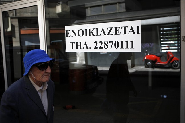 An elderly man passes an empty closed shop with a sign reading in Greek " To rent" in central Nicosia, Cyprus, Tuesday, April 9, 2013. Last month, Cyprus agreed that bondholders, investors and savers with more than 100,000 euros in the country's two largest — and most troubled — banks will take significant losses in exchange for a 10 billion euro ($13 billion) rescue package.